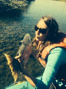 Adele Rife holding a dead salmon - photo by Jon Wilson